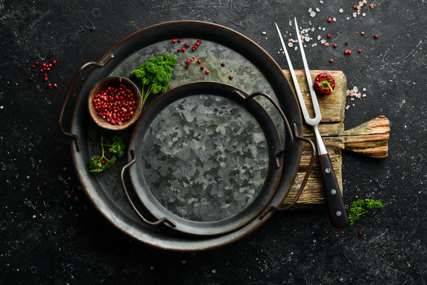 Black stone cooking background. Metal tray, Spices and vegetables. Top view. Free space for your text. - Fotografie, Obrázek