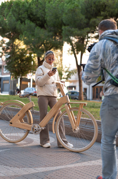 Стильна жінка з велосипедом за допомогою мобільного телефону
 - Фото, зображення