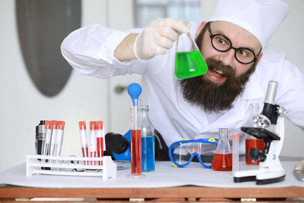 Chemik se zbláznil. Šílený vědec provádí experimenty ve vědecké laboratoři. Provede výzkum pomocí mikroskopu. - Fotografie, Obrázek