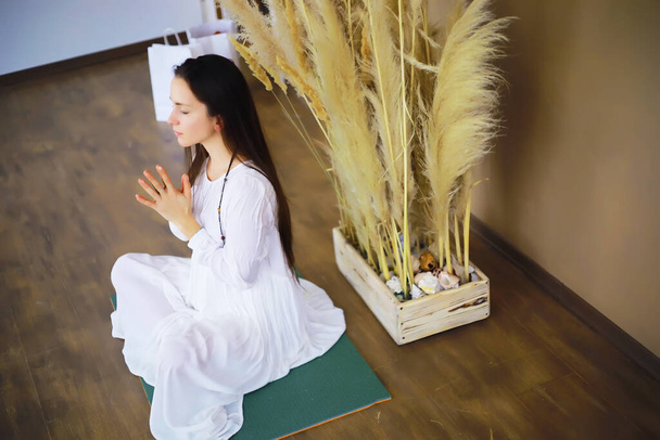 Hermosa chica atlética haciendo ejercicios de yoga disfrutar de la meditación en casa. Sin estrés, hábito saludable, concepto de alivio de la ansiedad. Loto. - Foto, imagen