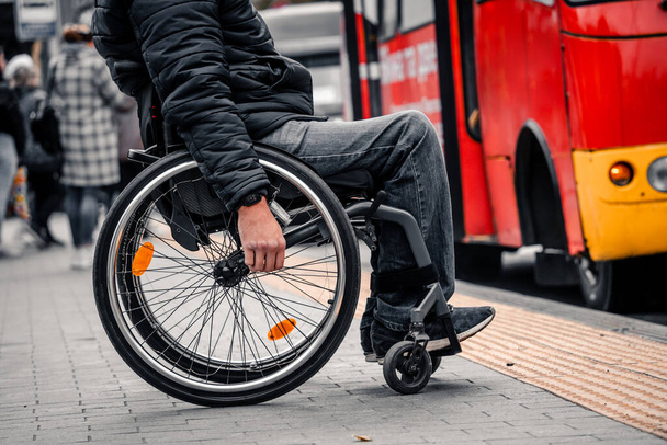 Osoba s tělesným postižením čeká na městskou dopravu s přístupnou rampou. - Fotografie, Obrázek