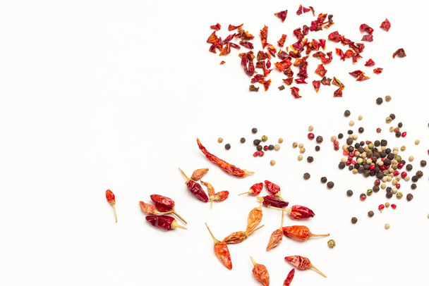 Dry pepper pods, allspice, and dry pepper petals on table. Copy space. Top view. White background - Foto, afbeelding