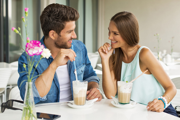 Smiling couple in cafe enjoying the time spending with each othe - Фото, изображение