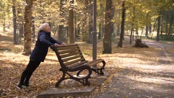 Fit aged woman doing push-ups in autumn park - Filmagem, Vídeo