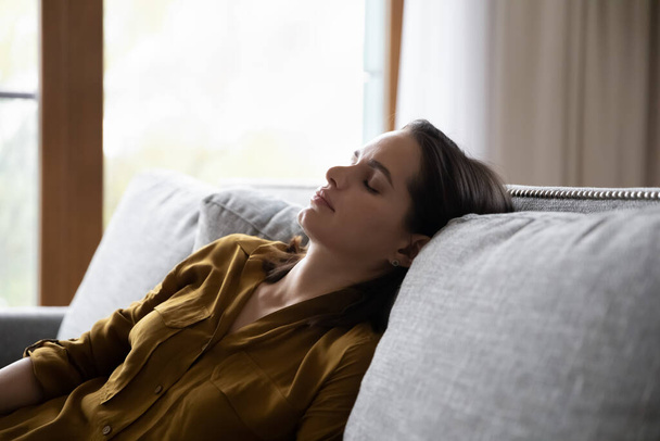 Tired millennial young woman sleeping in sitting position on couch - Foto, imagen