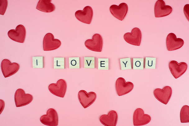 Red hearts and the text "I love you" on a pink background. View from above - Φωτογραφία, εικόνα