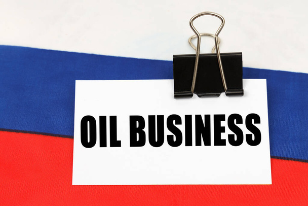 National concept. On the flag of Russia there is a business card with the inscription - Oil business - Foto, immagini