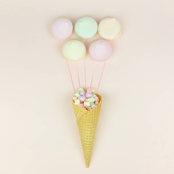 Wafer horn and marshmallow looks like macaroonson a pastel background, top view, flat lay, minimalist trend. Holiday and celebration concept. - Фото, изображение