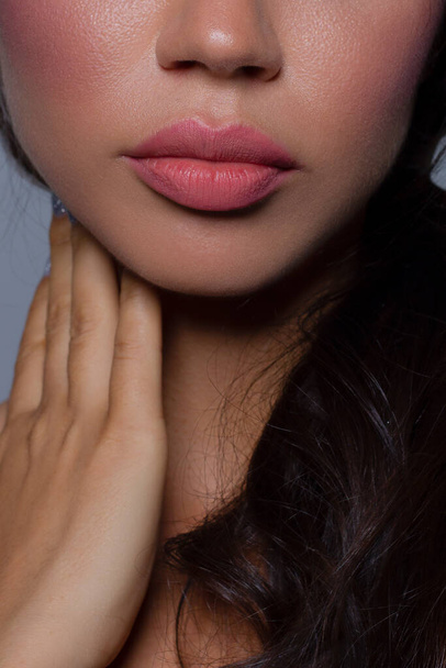 Cosmetics, makeup and trends. Bright lip gloss and lipstick on lips. Closeup of beautiful female mouth with natural lip makeup. Beautiful part of female face. Perfect clean skin in natural light - Foto, afbeelding