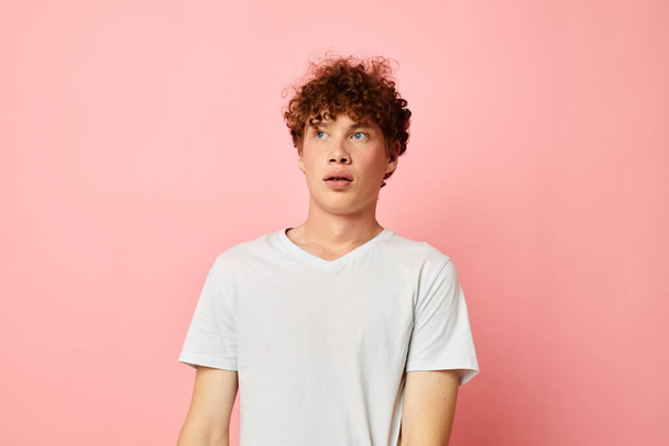 Young curly-haired man summer clothes white tshirt posing isolated background unaltered - Фото, изображение