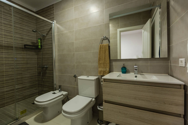 Spacious bathroom in gray tones with heated floors, walk-in shower, double sink vanity. - Фото, изображение