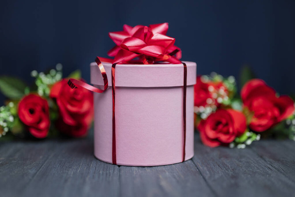 pink surprise gift box with red bow for birthday and happy valentine's day with flowers roses - Foto, Imagen