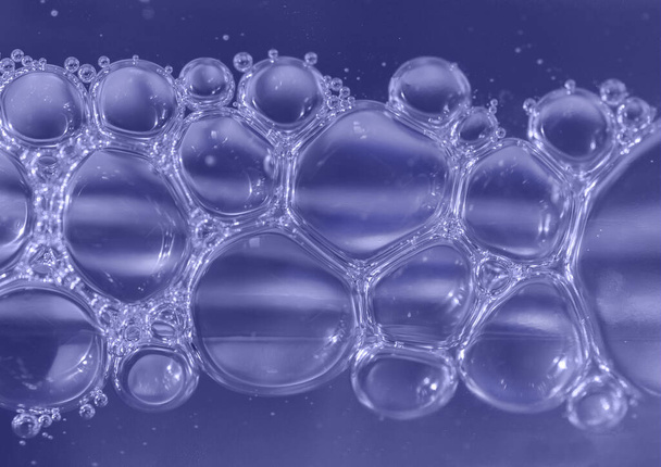 Air bubbles in violet blue beauty product bottle. Macro, close up picture - Fotó, kép