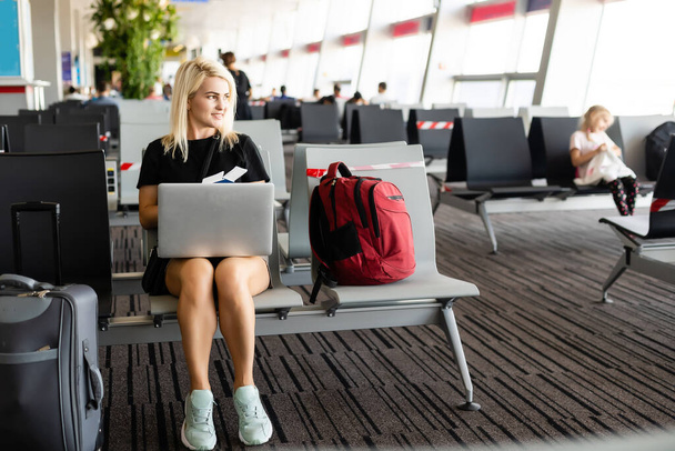 Mujer de negocios con maleta en salón del aeropuerto
 - Foto, imagen