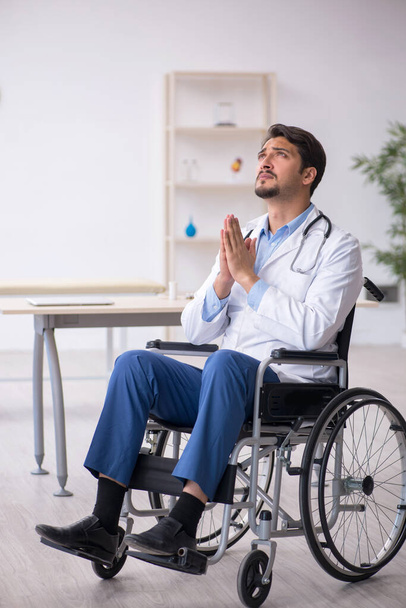 Jeune homme médecin en fauteuil roulant travaillant à la clinique - Photo, image