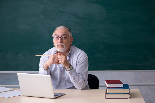 Vieux professeur masculin en face de la planche verte - Photo, image