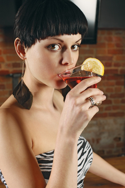 jonge vrouw drinken een martini - Foto, afbeelding