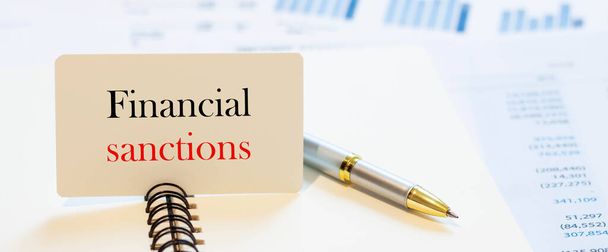 Financial sanctions - business text on pen background with accounting - Foto, Imagem