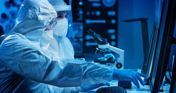 Scientists work in a modern scientific lab using laboratory equipment, microscope and computer technology. Invention of new vaccines. Concept of Science and Health. - 写真・画像