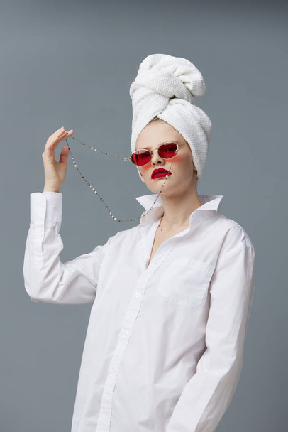 portrait of a woman red sunglasses cosmetics with towel on head isolated background - Foto, imagen