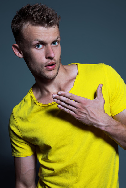 Emotive portrait of muscular young handsome man in bright yellow - Φωτογραφία, εικόνα
