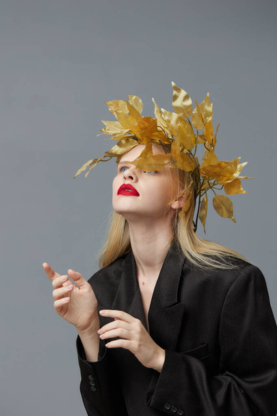 λαμπερή γυναίκα χρυσά φύλλα στο κεφάλι σε μαύρο σακάκι μοντέλο στούντιο αναλλοίωτη - Φωτογραφία, εικόνα