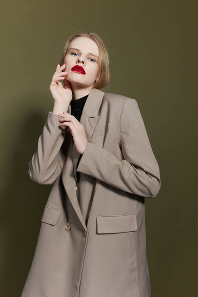όμορφη γυναίκα με κόκκινα χείλη κρατά το χέρι κοντά στο πρόσωπο στούντιο μοντέλο αναλλοίωτη - Φωτογραφία, εικόνα
