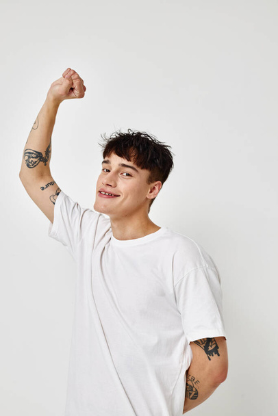 portrait of a young man modern youth style white t-shirt tattoo on the arm model studio - 写真・画像