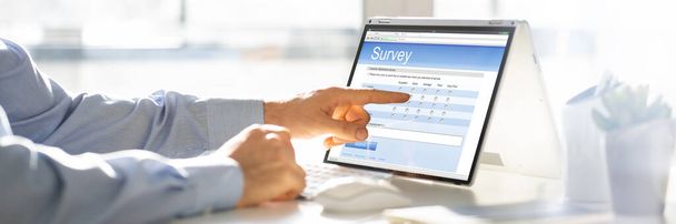 Businessperson Filling Online Survey Form On Digital Laptop - Fotografie, Obrázek