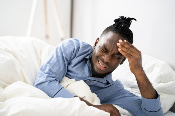 Sick African American Man With Headache In Bed - Фото, изображение