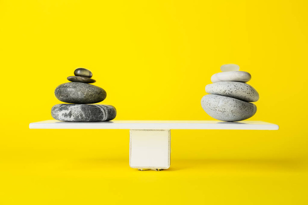Πέτρες σπα σε πλακέτα με κίτρινο φόντο. Έννοια της ισορροπίας - Φωτογραφία, εικόνα