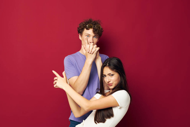 guy and girl posing studio red background - Fotó, kép