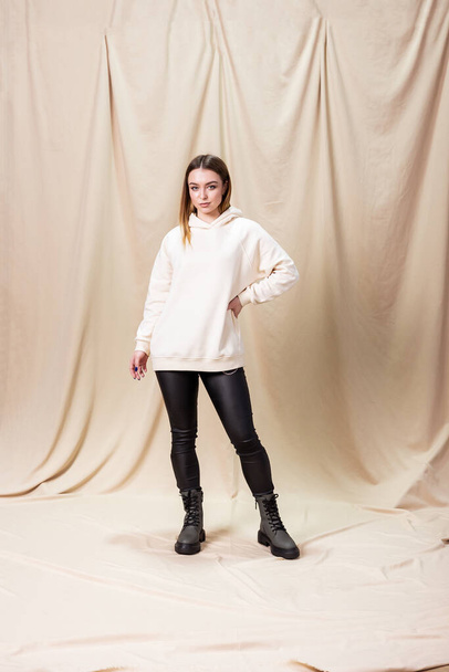 Young woman in a sweater and leather leggings. Woman in boots with natural leather on low soles - Photo, image