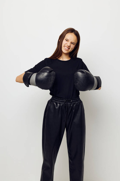 young beautiful woman in boxing gloves punch in black pants and a T-shirt Lifestyle unaltered - Photo, image