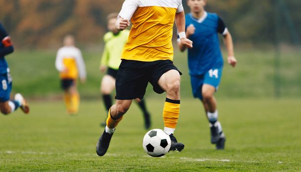 Adult Football Players Kicking Soccer Ball. Soccer Competition Between Two Teams. Soccer League Match. Player in Football Cleats in Run - Фото, изображение