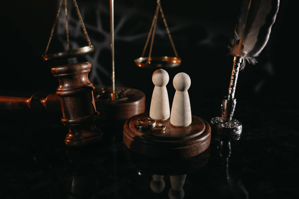 Lei e Justiça. Imagem vertical de martelo juiz, figuras de madeira e anéis de casamento - Foto, Imagem