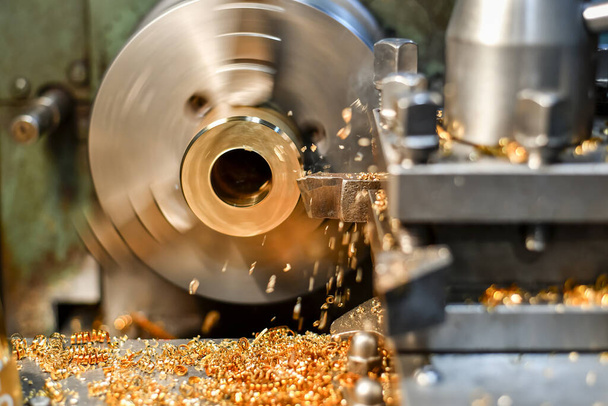 A turner makes a bronze bushing on a lathe by removing chips with a mechanical cutter. - Foto, Imagem