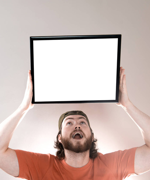 Mladý pohledný vousatý muž ukazující prázdný tabule, izolované na šedém pozadí - Fotografie, Obrázek