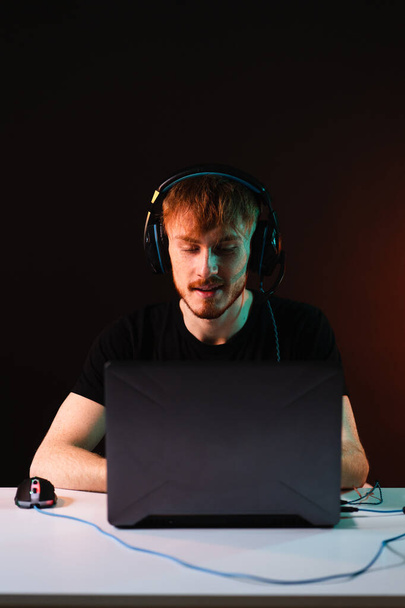 Геймер грає у відеоігри з навушниками на фоні неонового світла
 - Фото, зображення