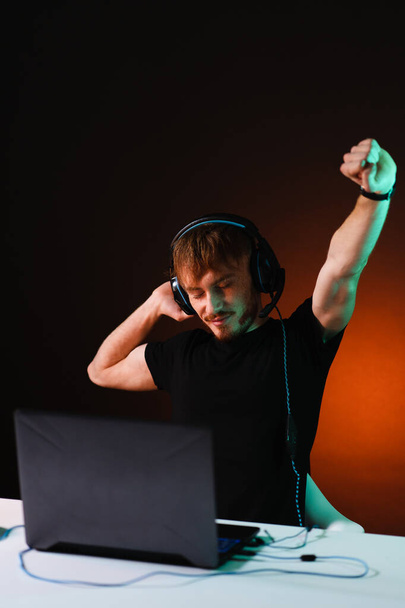 Gamer spelen van videospelletjes met hoofdtelefoon op neon lichte achtergrond - Foto, afbeelding