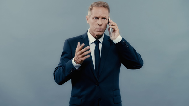 Mature manager talking on cellphone isolated on grey  - Foto, afbeelding