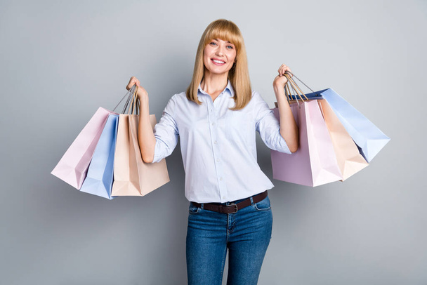 Photo of shiny cute woman wear formal shirt holding shopping bags isolated grey color background. - Foto, Bild