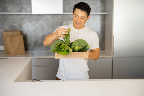 Ember szagolja friss bio zöldségek fadobozban - Fotó, kép