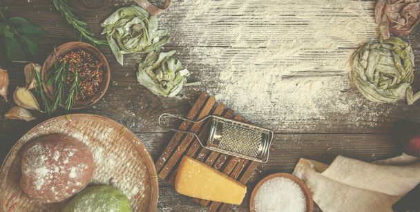 Ingredients for making pasta on a rustic background, top view. Flat lay. Italian recipe. Hand made. Process of making raw pasta. Manufacturing fresh italian pasta. - 写真・画像