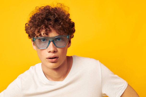 guy with red curly hair in a white t-shirt blue fashion glasses Lifestyle unaltered - Foto, imagen