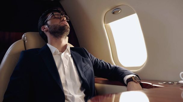 Businessman in formal wear sleeping in private jet  - Photo, Image