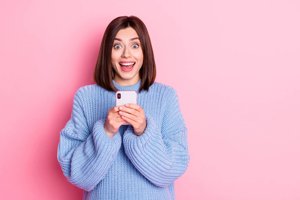 Portrait of attractive amazed cheerful girl influencer using gadget having fun like smm media isolated over pink pastel color background. - Fotografie, Obrázek