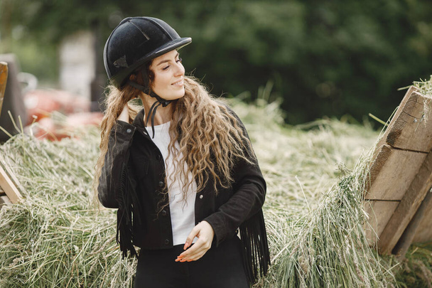 Portrait of rider woman in a black helmet on a farm - Foto, Imagen