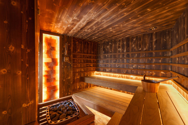 Empty wooden steam room with stone heater - Foto, afbeelding