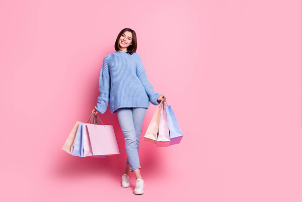 Full length body size view of attractive cheerful girl black friday carrying new clothes bags isolated over pink pastel color background. - Fotó, kép